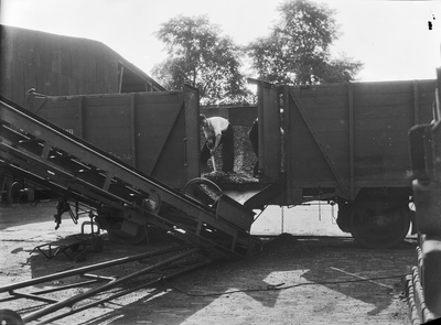 167305 Afbeelding van het lossen van steenkolen uit open goederenwagens van de N.S. te Utrecht.